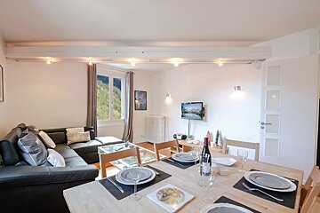 A living room with a couch and a dining table
