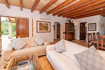 A living room with a white couch and wooden beams