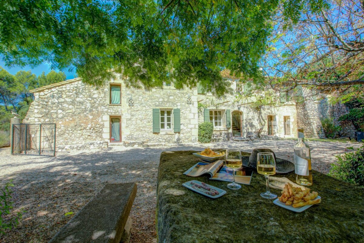 A bottle of wine sits on a table in front of a stone building