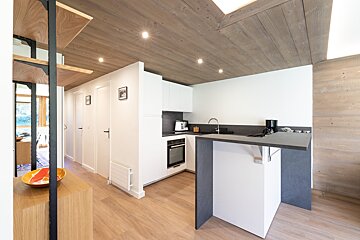 A kitchen with white cabinets and a black counter top