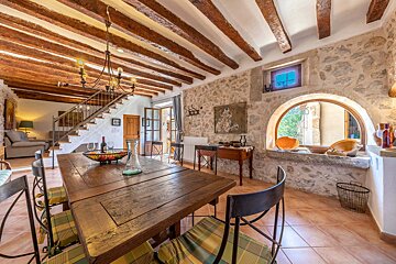 A dining room with a wooden table and chairs