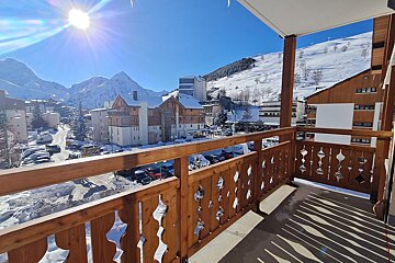 A balcony overlooking a snowy city with mountains in the background