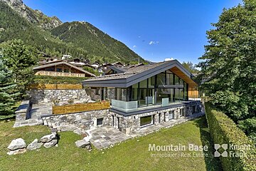 A house with a mountain in the background is for sale by mountain base