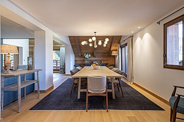 A dining room with a long table and chairs