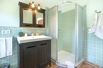 A bathroom with a sink and a walk in shower