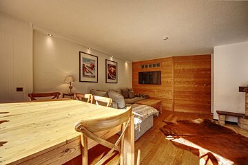 A living room with a couch and a table with a picture of a skier on the wall