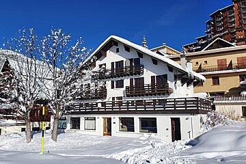 A snow covered building with a yellow pole in front of it