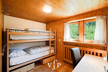 A bedroom with bunk beds and a desk with vfp written on it