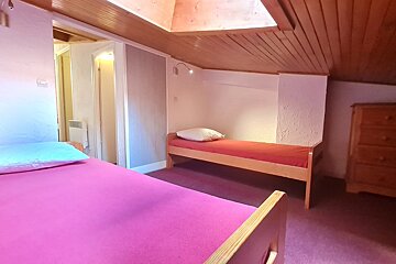 A bedroom with two beds and a dresser