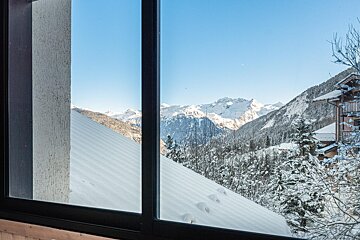 A view of snow covered mountains from a window