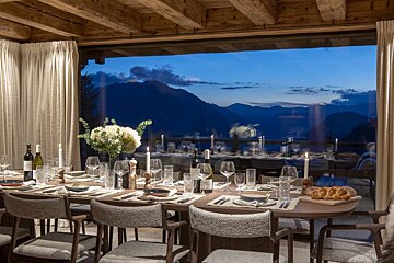 A dining room with a view of the mountains at night