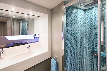 A bathroom with blue tiles and a sink