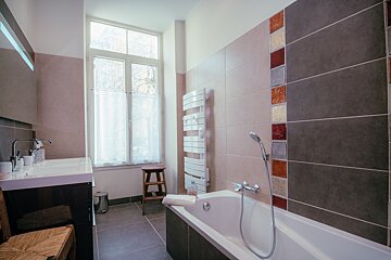 A bathroom with a picture of a cow on the wall above the sink