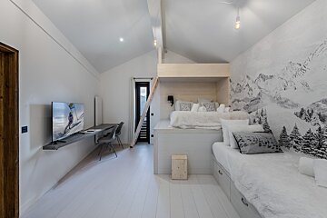 A bedroom with a bunk bed and a flat screen tv