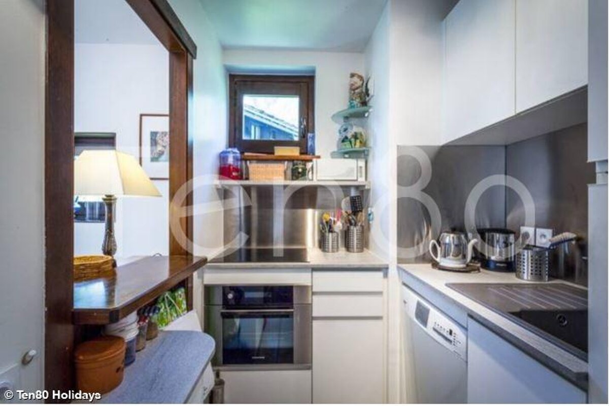 A small kitchen with white cabinets and stainless steel appliances