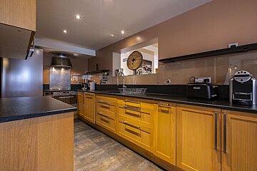 A kitchen with yellow cabinets and black counter tops