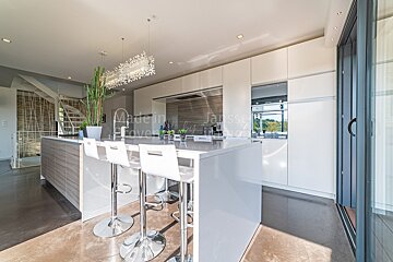 A kitchen with white cabinets and stools and a sign that says made in france