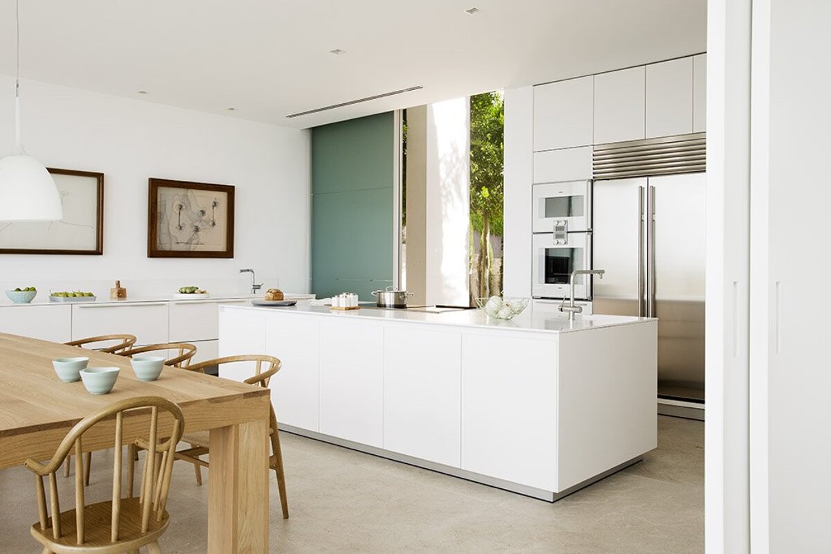 A kitchen with white cabinets and a stainless steel refrigerator