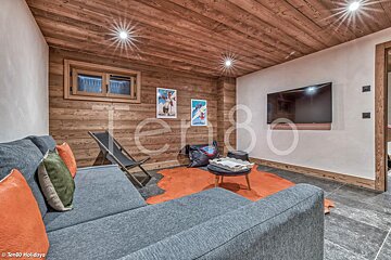 A living room with a couch and a television with the number ten80 on the wall