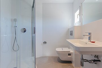 A bathroom with a toilet a sink and a shower