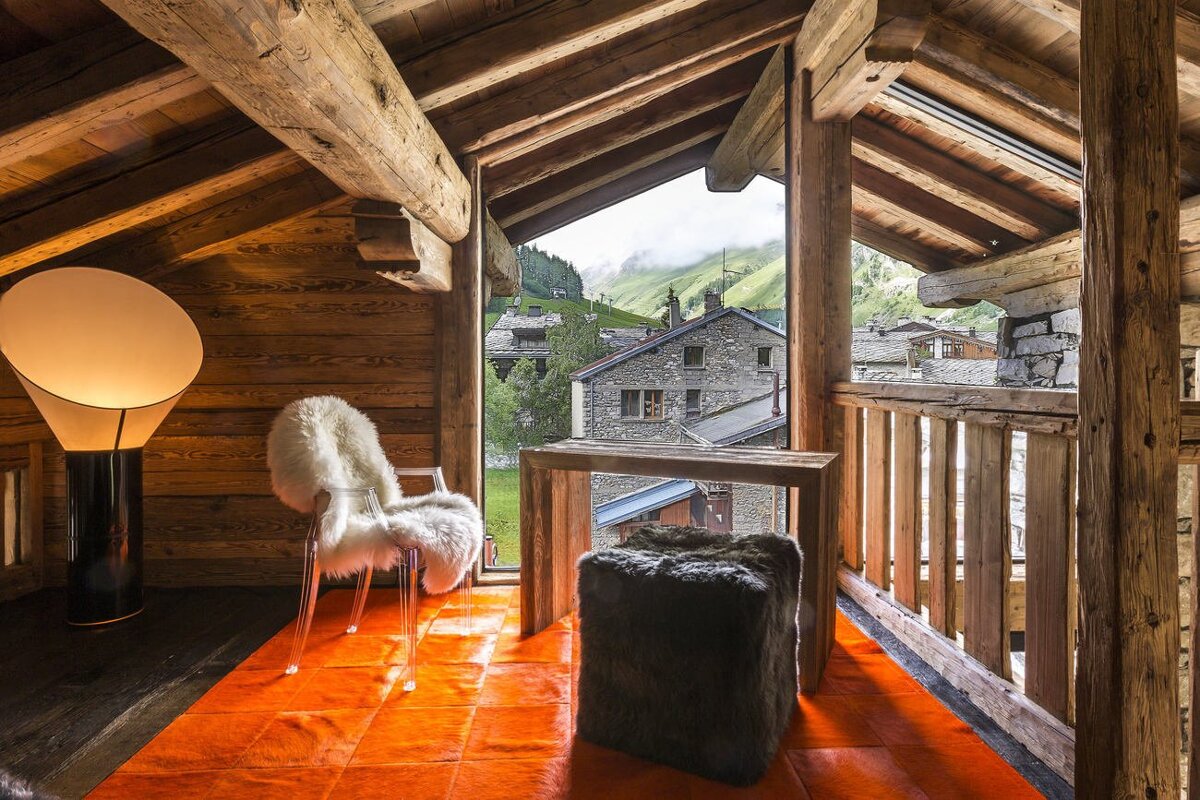 A chair in a room with a view of a mountain