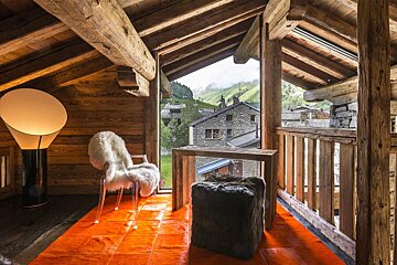 A chair in a room with a view of a mountain