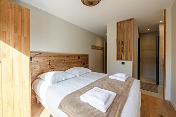 A bedroom with a bed and a wooden headboard