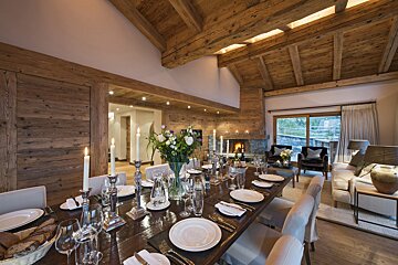 A dining room table with plates and candles on it