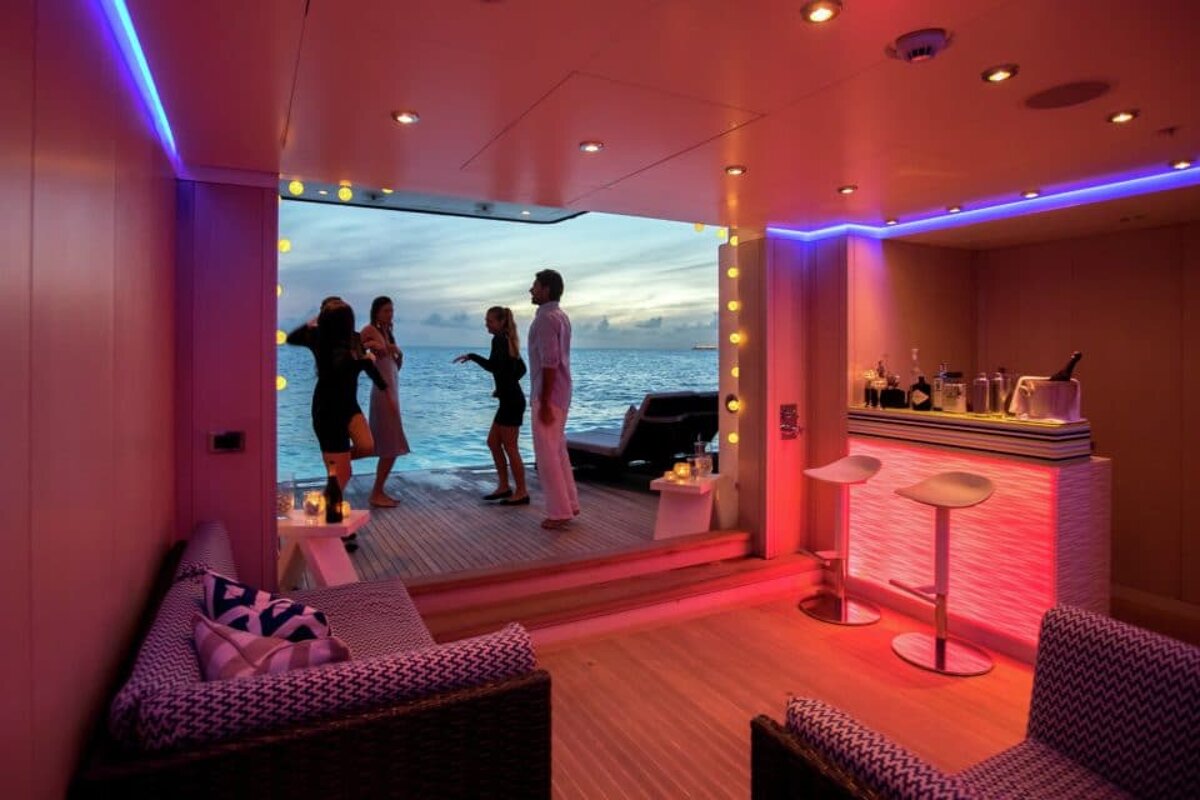 A group of people standing in a room with a view of the ocean