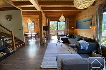 A living room with a couch and stairs and a sign that says alpin property