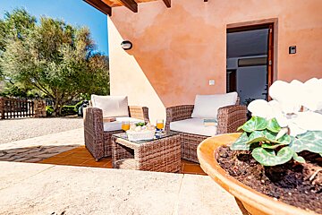 A patio with wicker furniture and a glass table