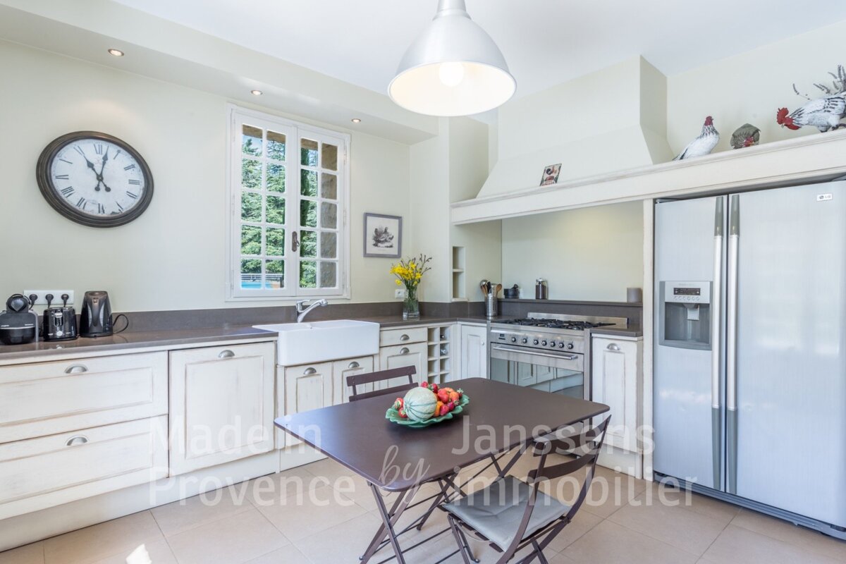 A kitchen with a table and chairs and a clock on the wall
