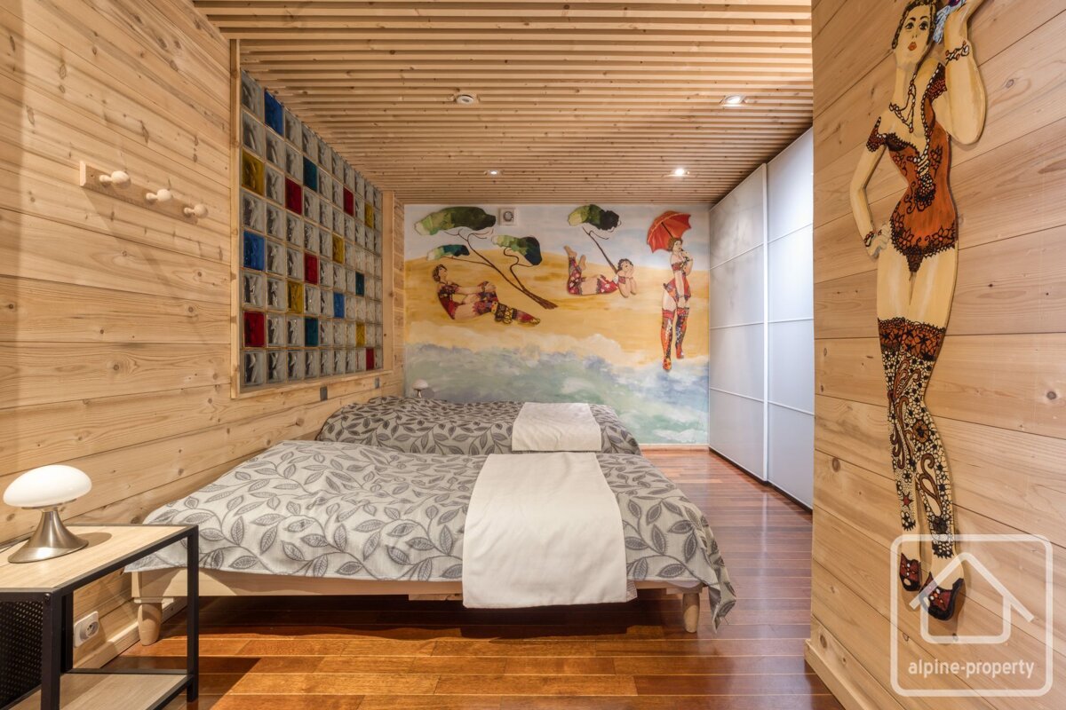 A bedroom with two beds and a painting on the wall that says alpine property
