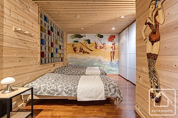 A bedroom with two beds and a painting on the wall that says alpine property