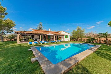 A house with a large swimming pool in front of it