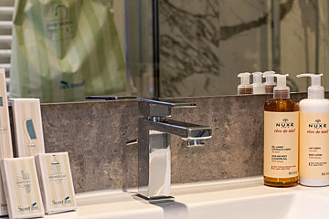 Two bottles of nuxe are on a bathroom sink
