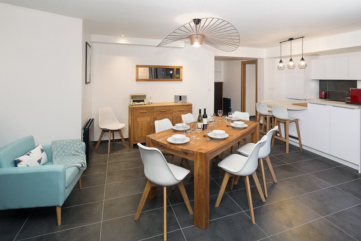 A dining room with a wooden table and white chairs