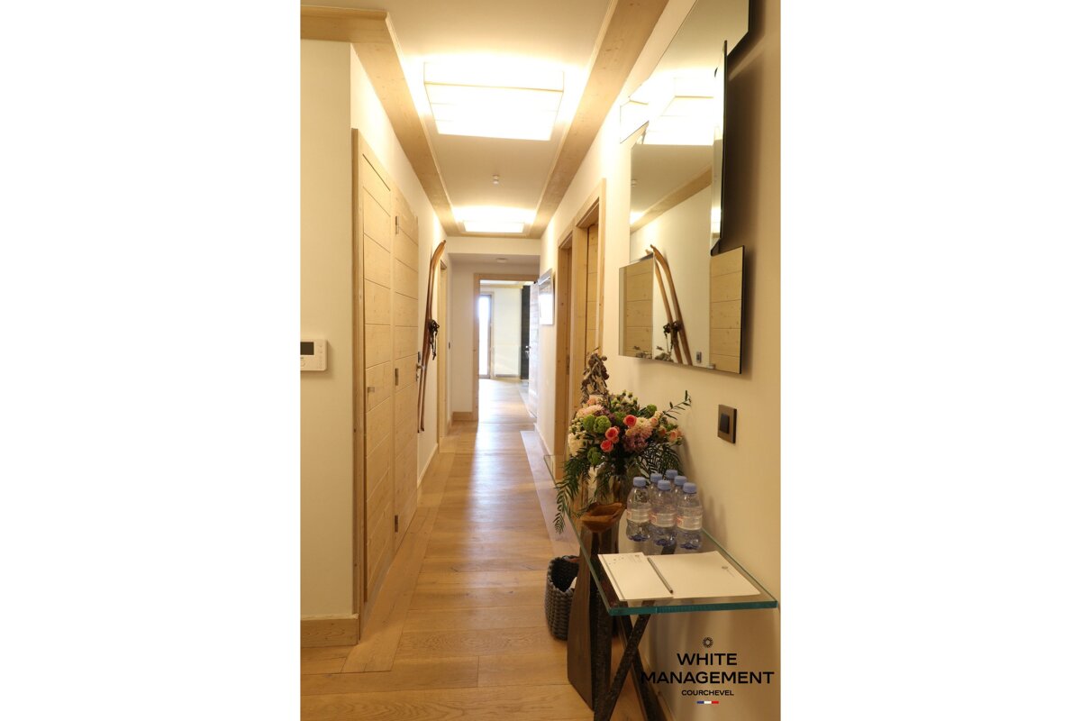 A long hallway with a white management sign on the wall