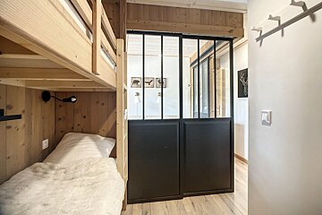 A bedroom with bunk beds and a sliding glass door