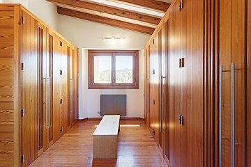 A long hallway with wooden cabinets and a window
