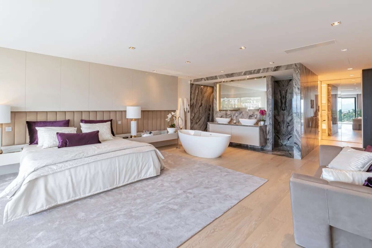 A bedroom with a bathtub and two sinks