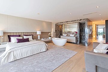 A bedroom with a bathtub and two sinks