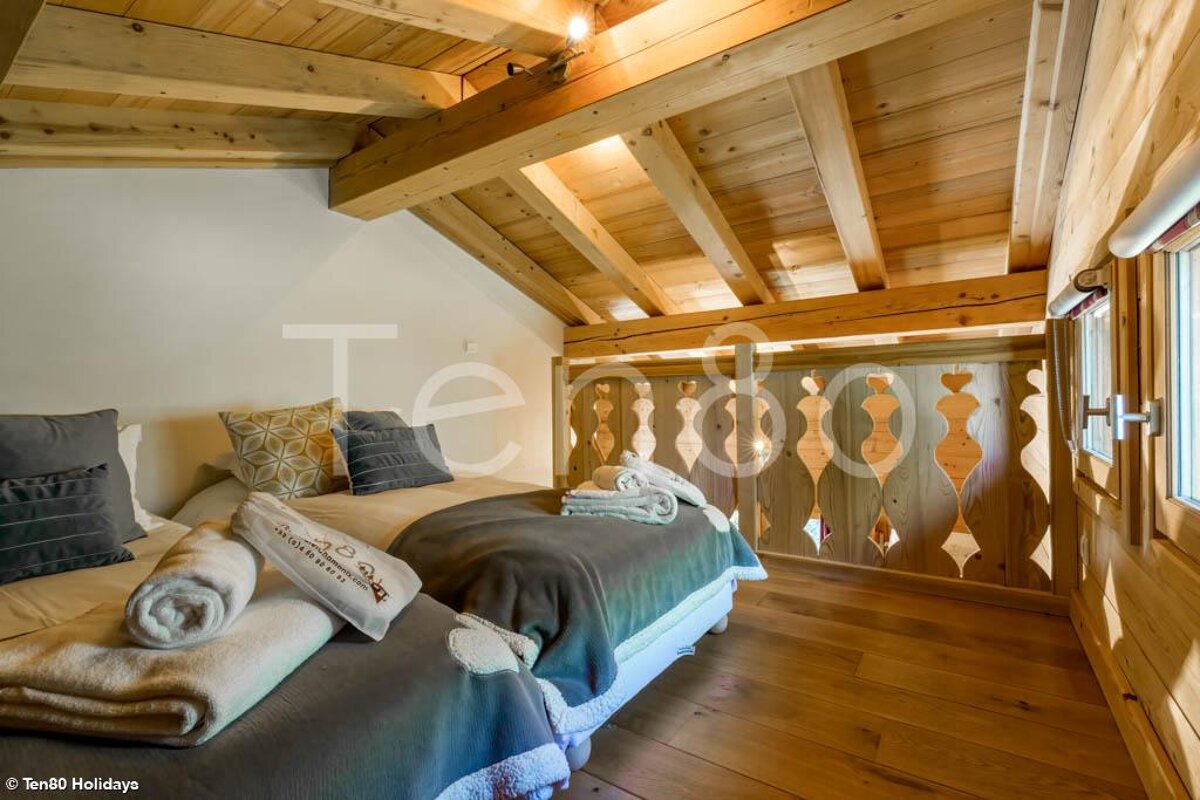 A bedroom with two beds and a sign that says ten80 holidays