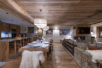 A dining room with a long table and a fireplace