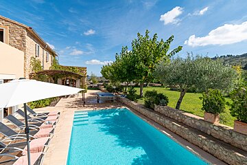 A large swimming pool surrounded by chairs and umbrellas