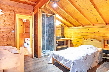 A bedroom with a single bed and a walk in shower