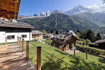 A view of the mountains from a deck with a fence