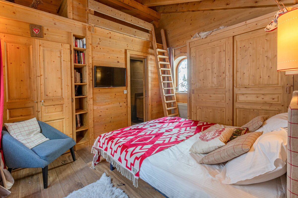 A wooden bedroom with a bed and a ladder