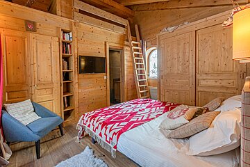 A wooden bedroom with a bed and a ladder