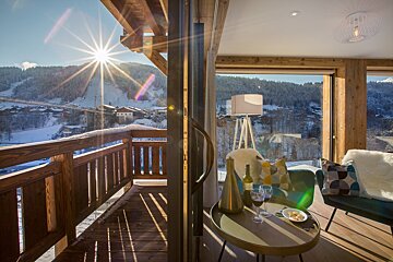 A table with a bottle of wine and two glasses on it